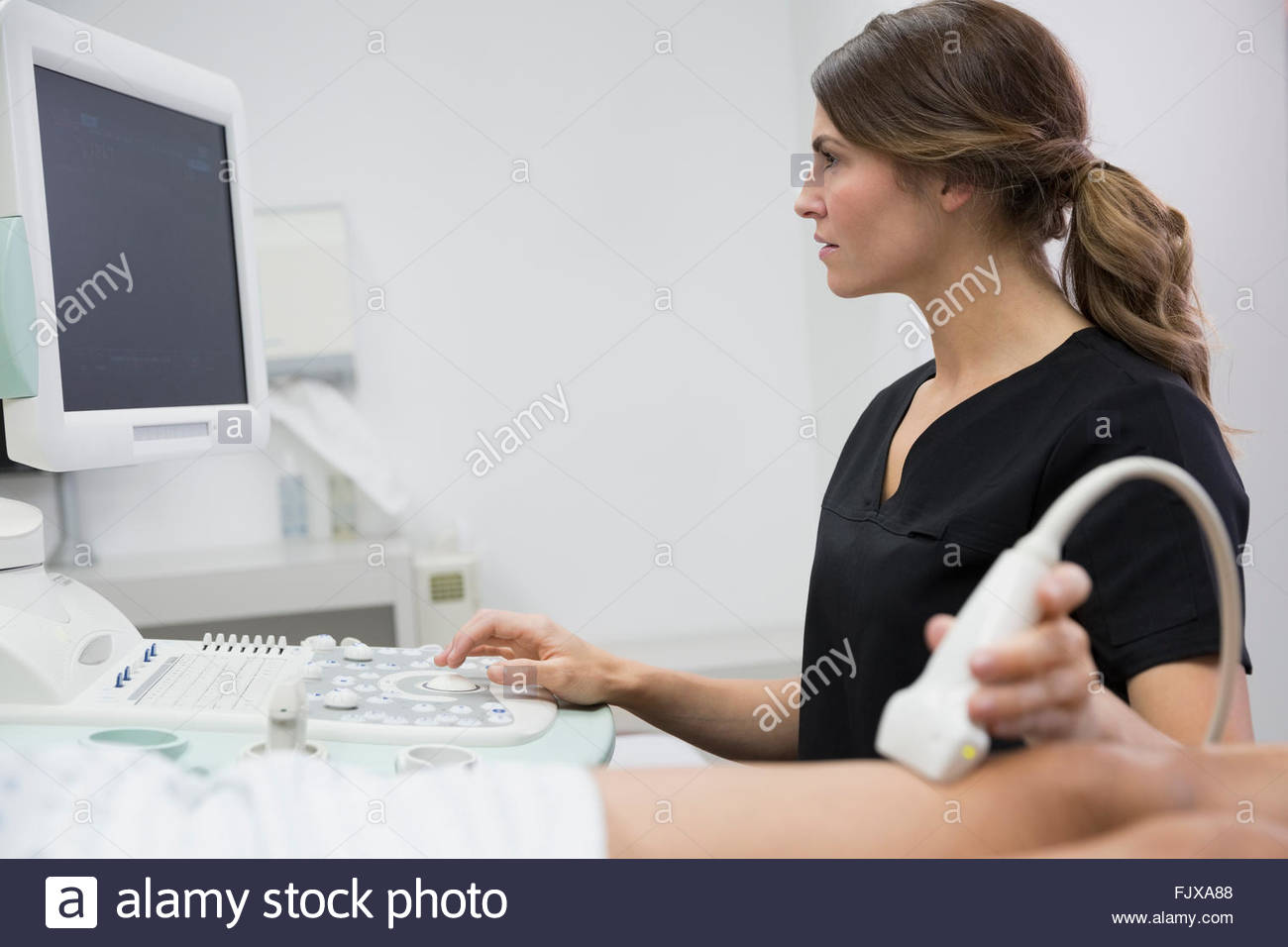 Technician treating varicose veins womans leg ultrasound equipment Stock Photo