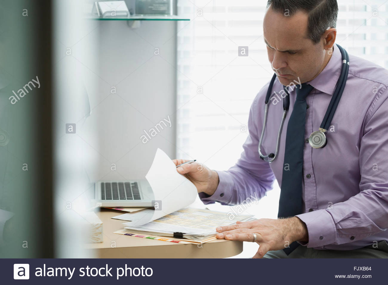 Doctor reviewing medical record Stock Photo