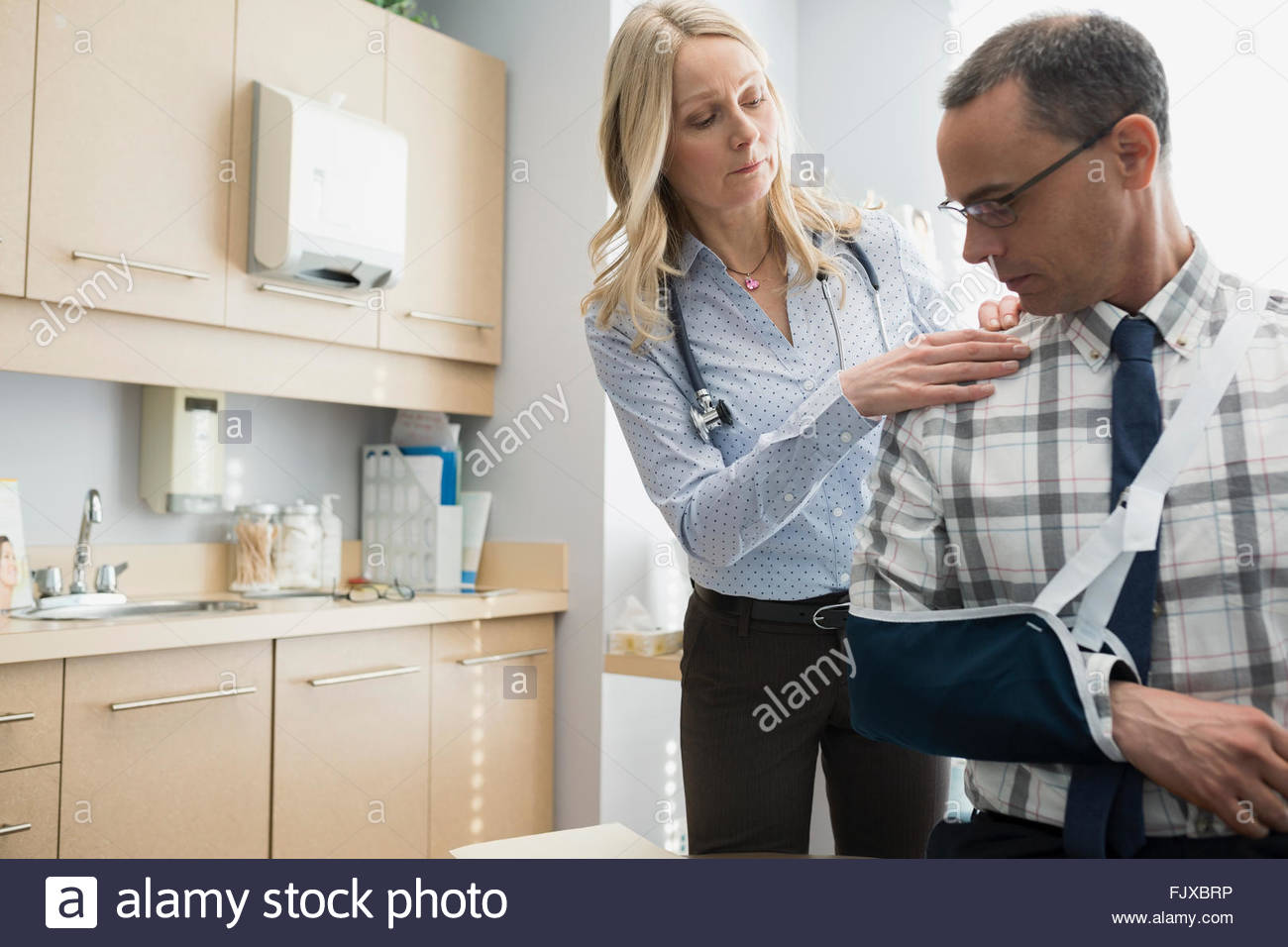 Female doctor checking patients shoulder in arm sling Stock Photo Alamy