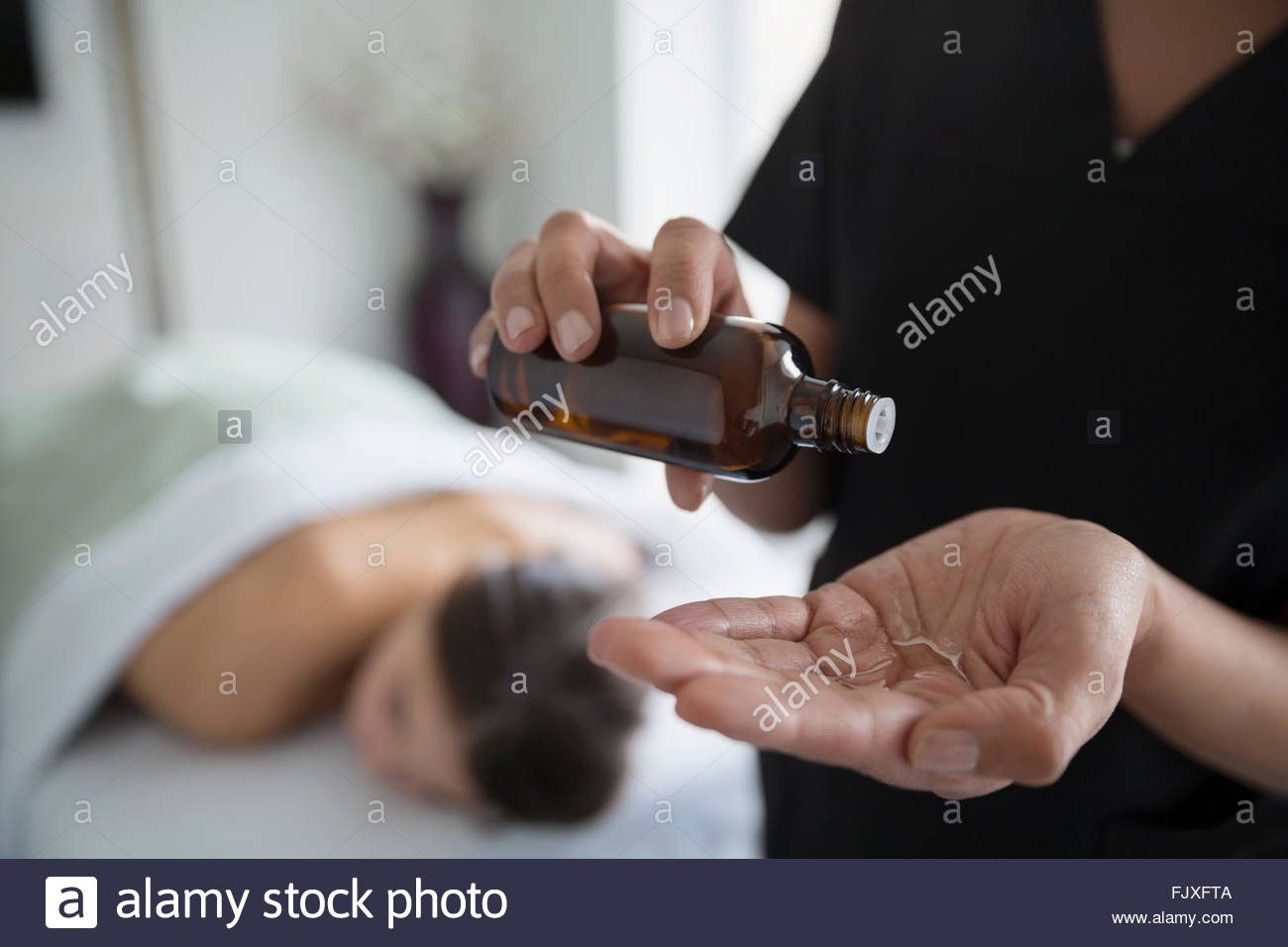 Massage therapist applying oil to hand Stock Photo Alamy