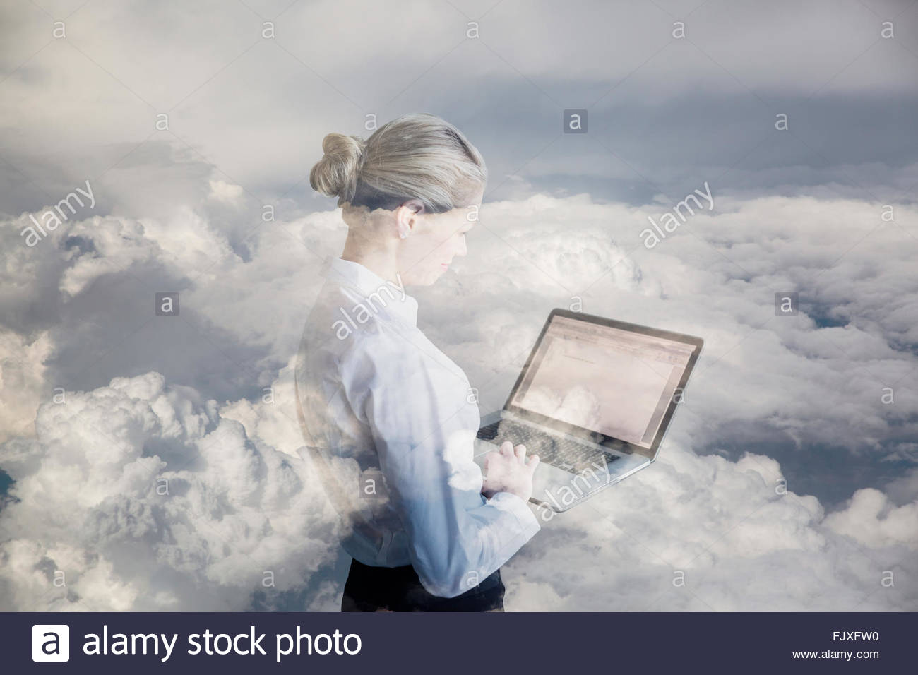 Digital composite businesswoman using laptop in clouds Stock Photo