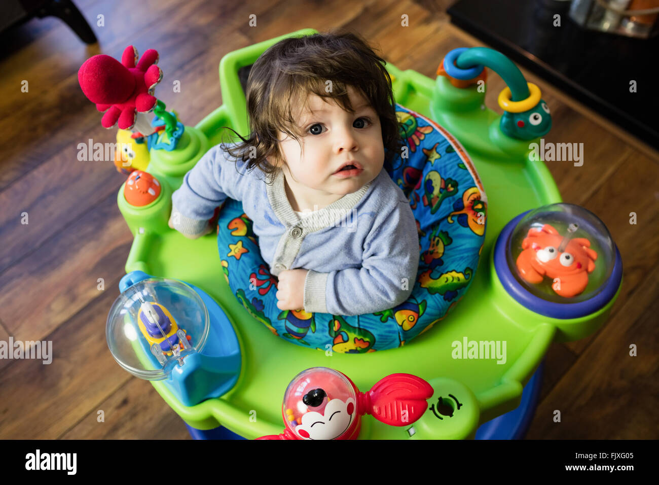 Cute baby sitting on his baby chair to play Stock Photo