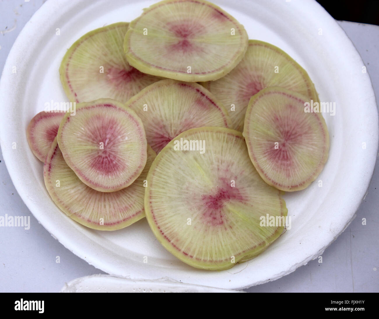 Raphanus sativus, Palam Hriday Radish sliced, cultivar with globose medium sized roots, flesh with pink and light green patches Stock Photo