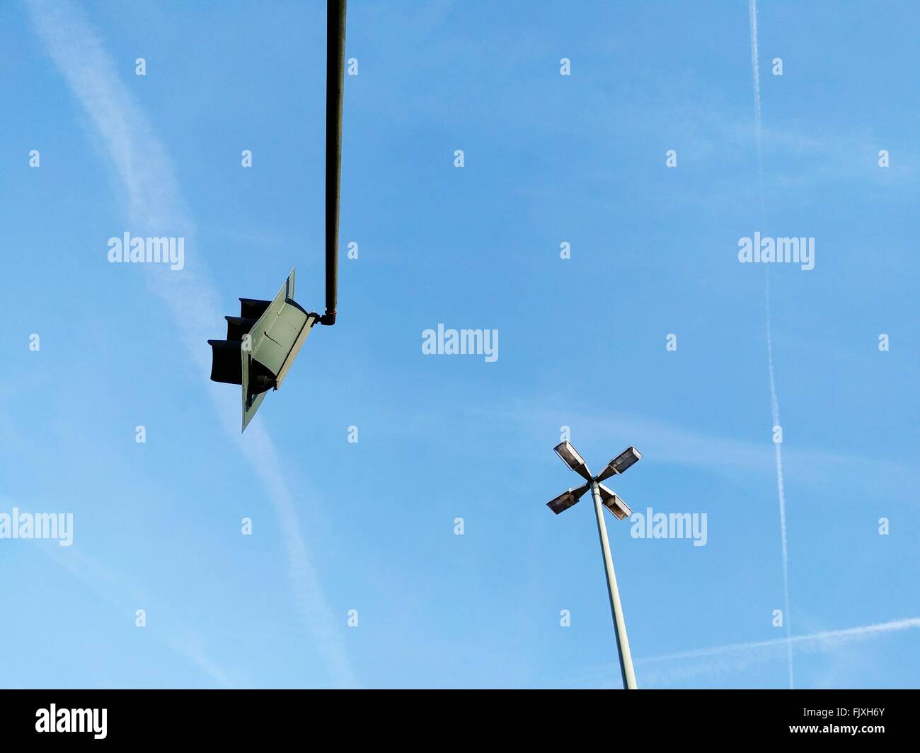 Low Angle View Of Floodlight And Road Signal Against Sky Stock Photo