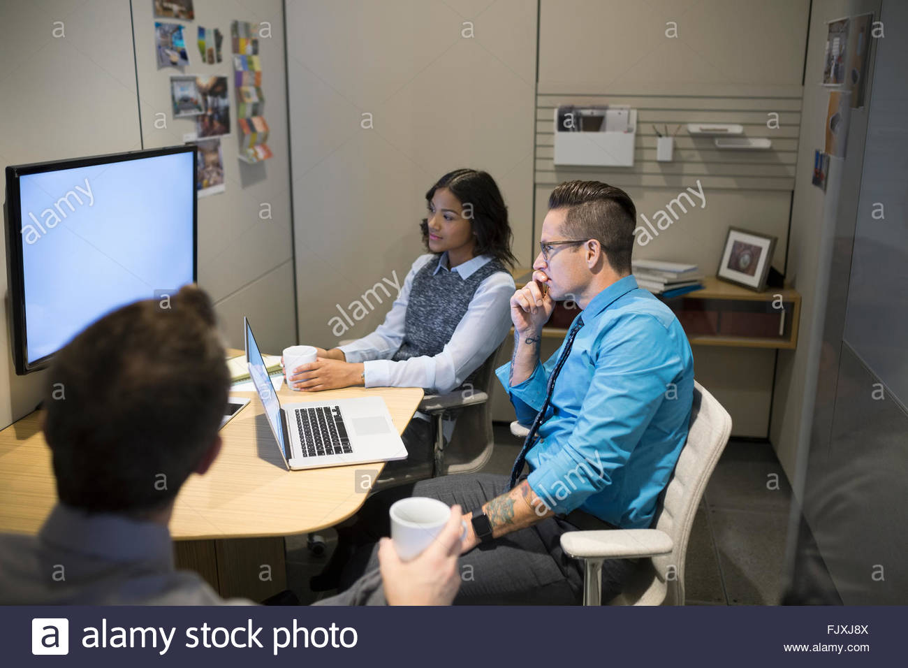 Business people watching monitor in meeting Stock Photo