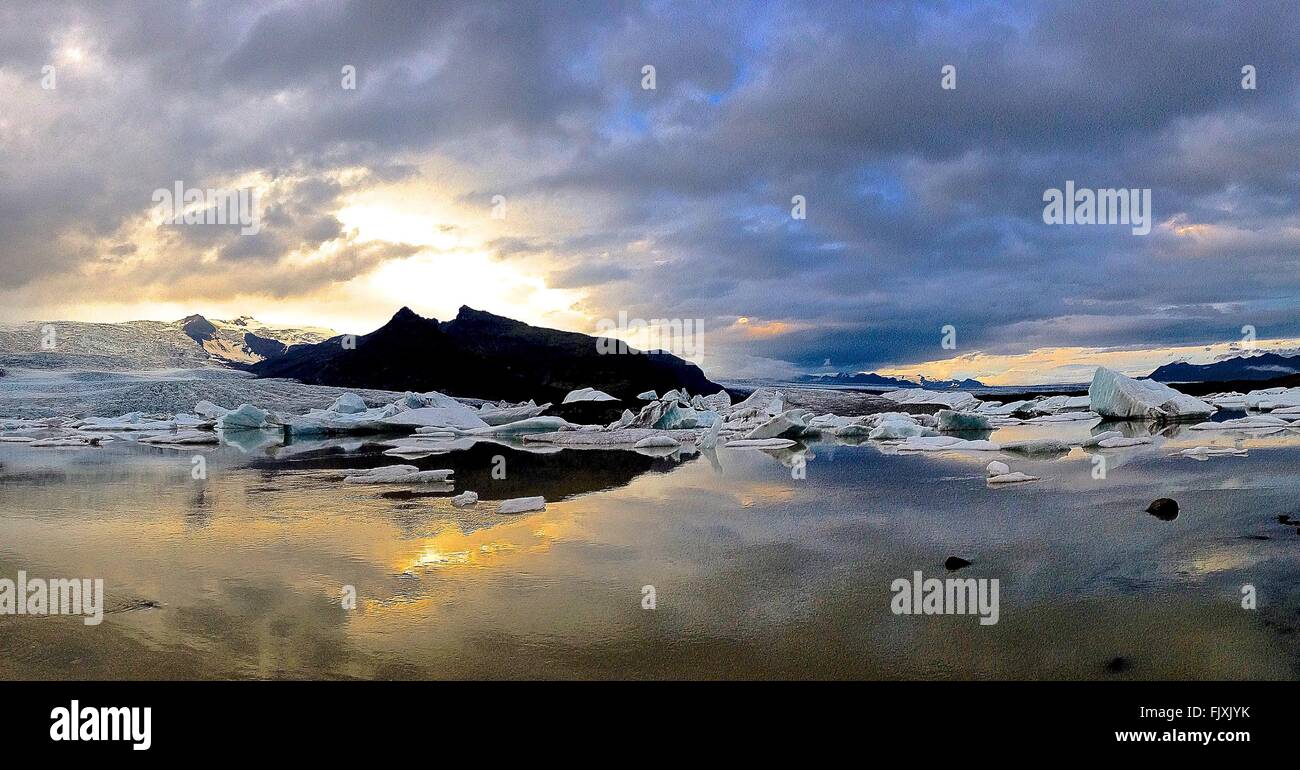 Scenic View Of Frozen Glacier In Jokulsarlon Lake Against Cloudy Sky Stock Photo