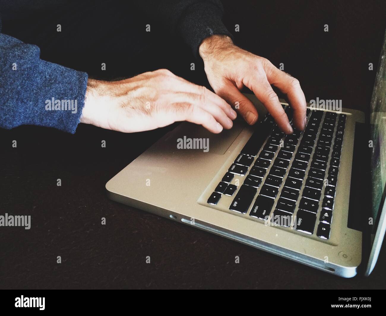 Cropped Image Of Hand Typing On Laptop Stock Photo