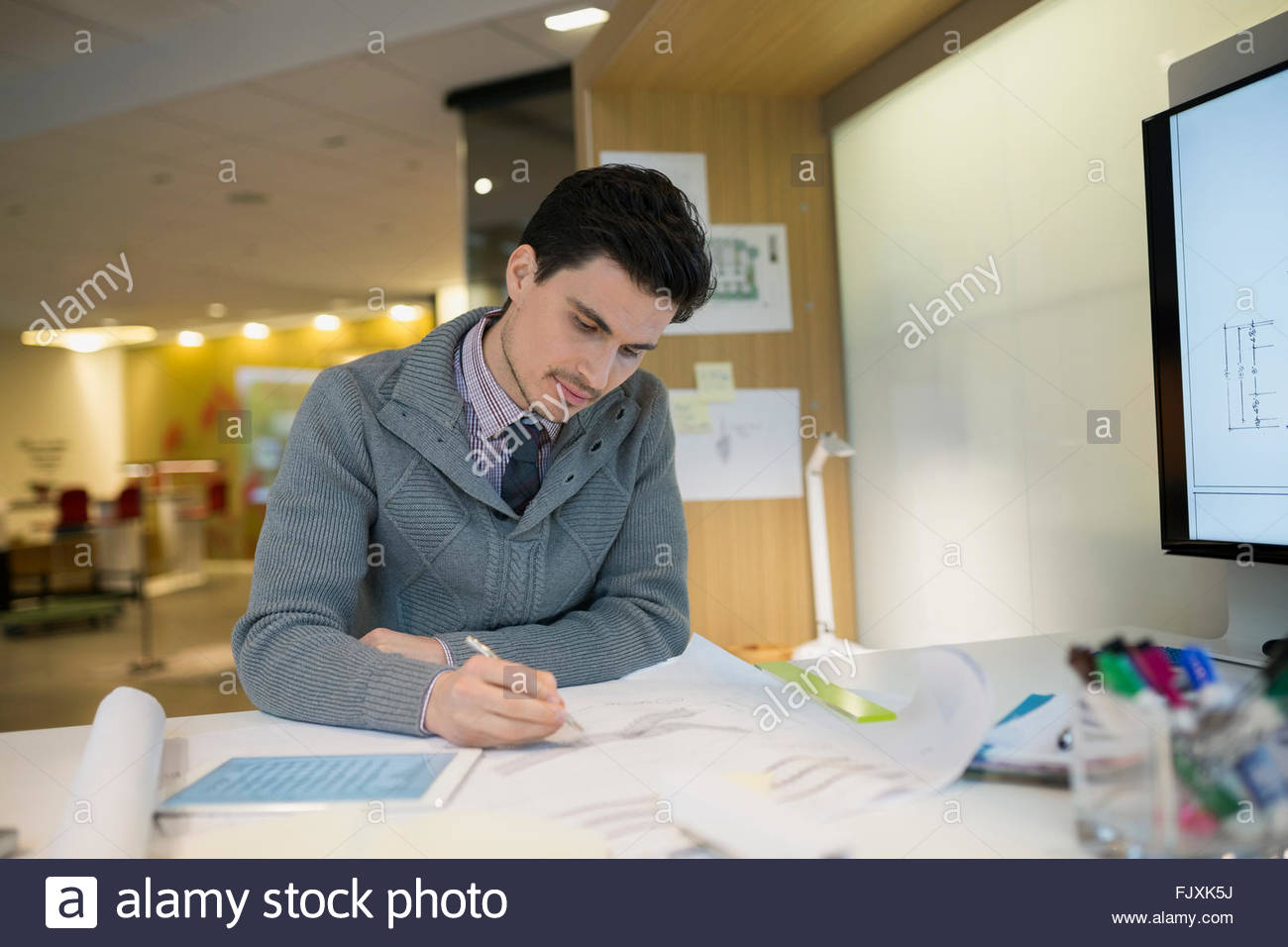 Architect drafting plans at office desk Stock Photo