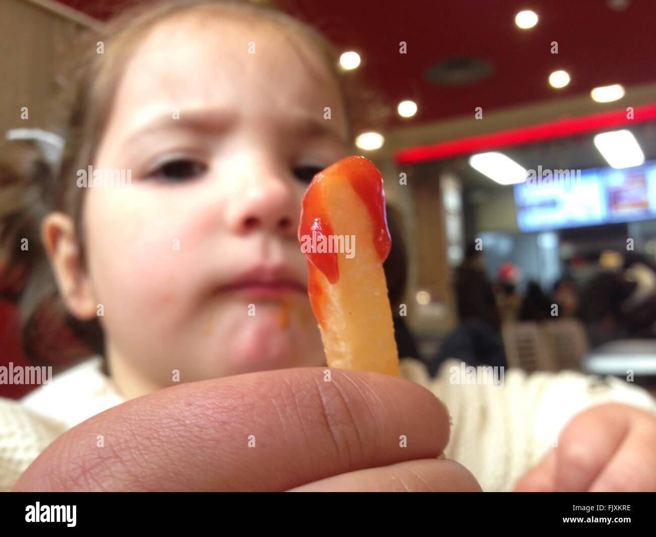 Happy little girl eating fast food. French fried with ketchup sauce Stock Photo Alamy