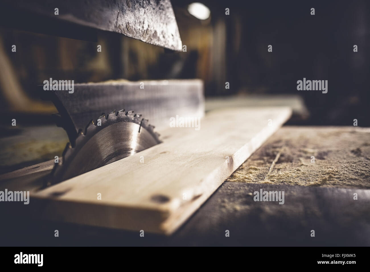 Saw sawing plank of wood Stock Photo