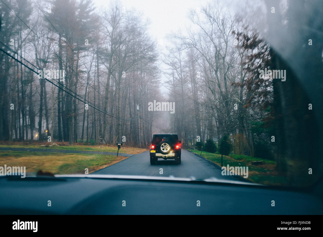 Sport Utility Vehicle Seen Through Car Windshield On Road In Foggy