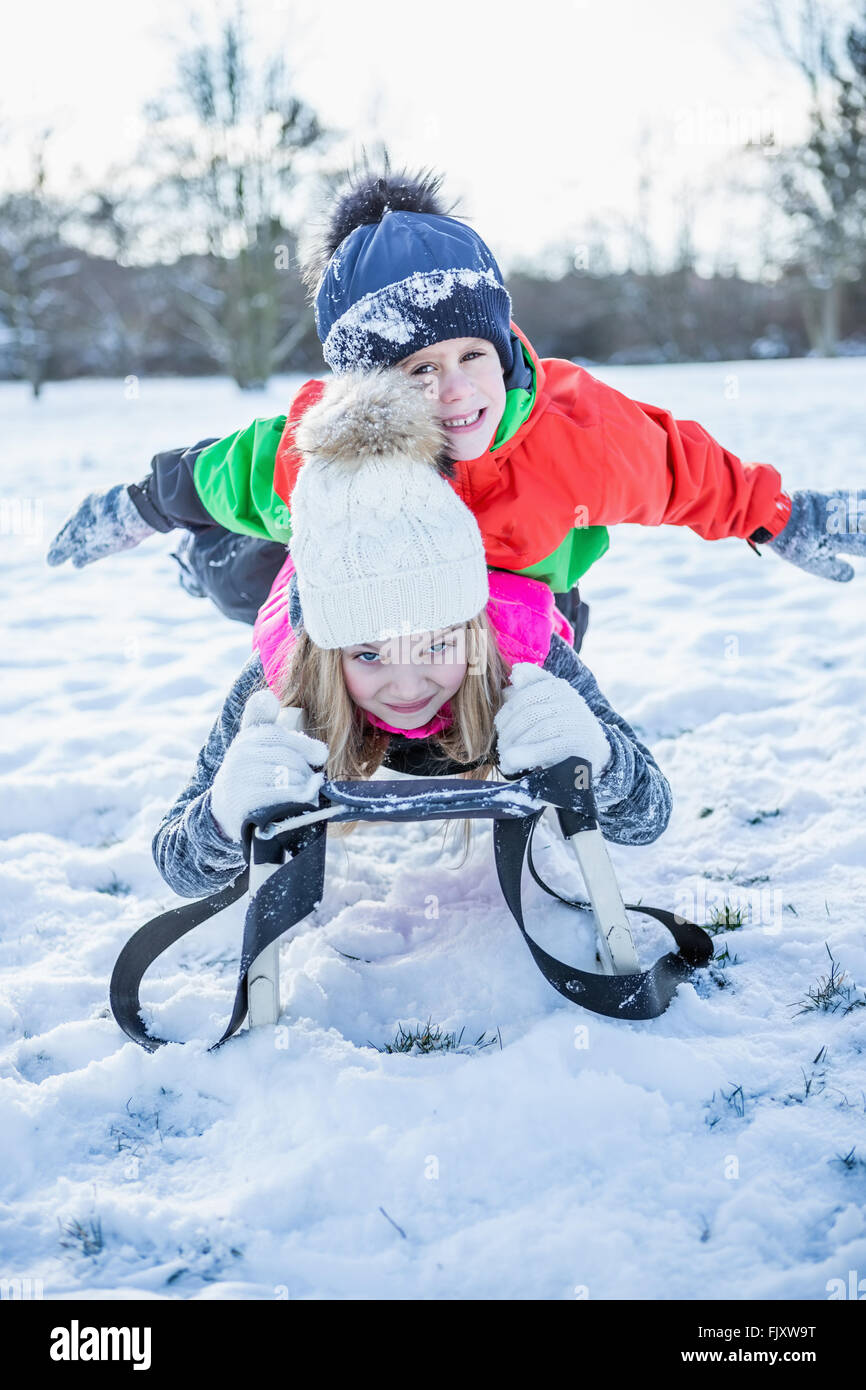 Siblings playing in the snow Stock Photo - Alamy