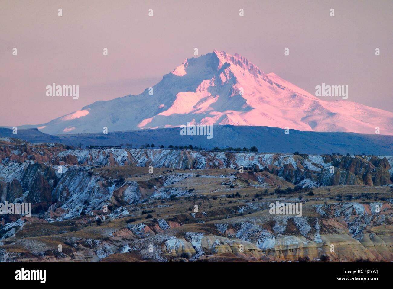 Snow covered volcanic 3916m peak of Mount Erciyes, highest mountain in central Anatolia Turkey. S.E. over gorges of Goreme. Dusk Stock Photo