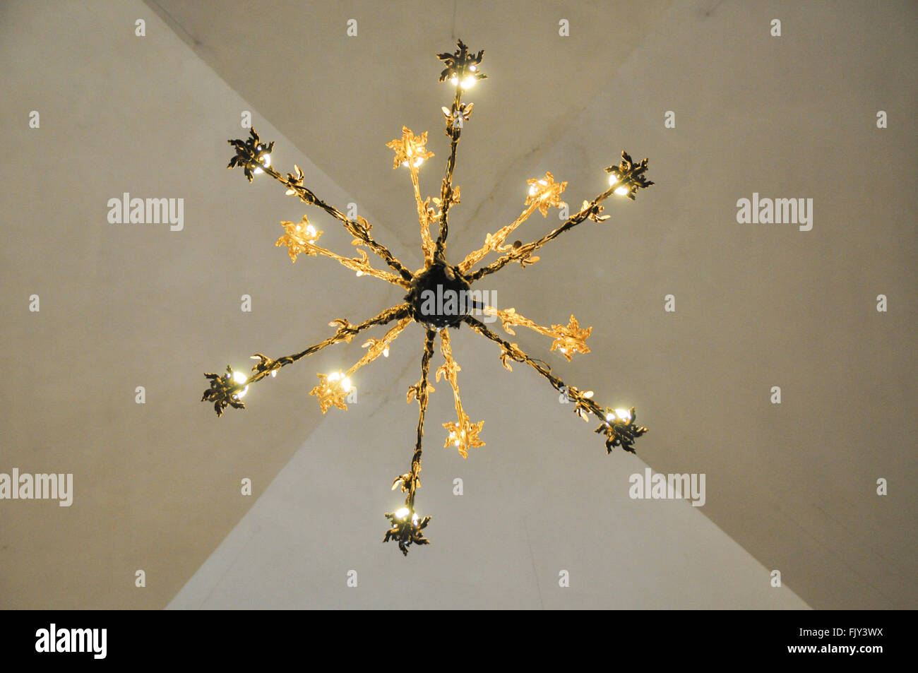 Directly Below Shot Of Illuminated Chandelier Hanging From Ceiling Stock Photo