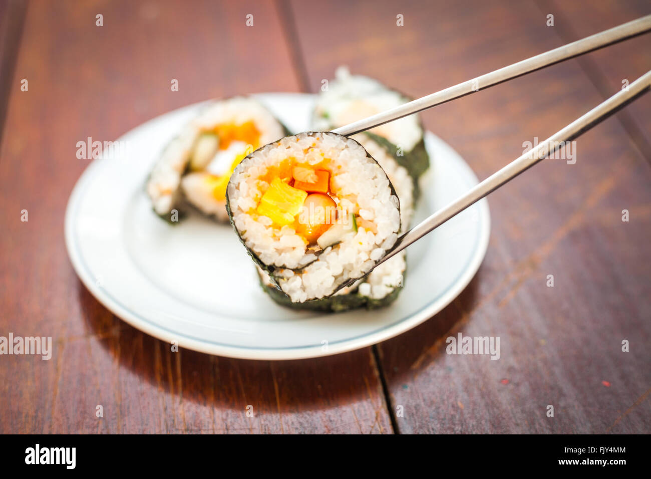 Rice sushi rolls assortment on white plate and gray chopsticks Stock Photo