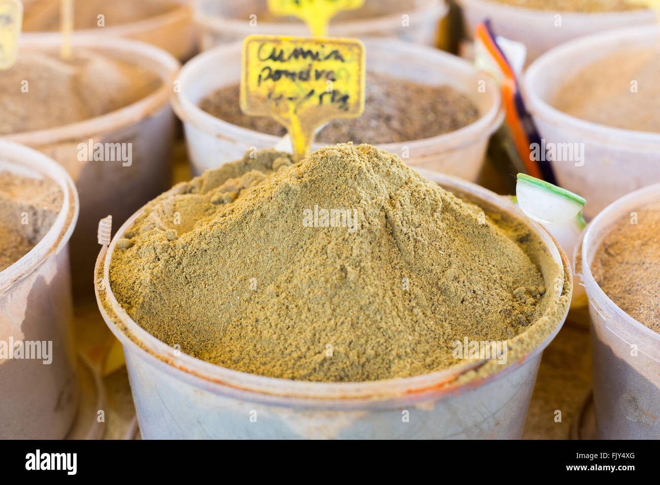 Different spices like cardamom, cumin coriander in transparent pots