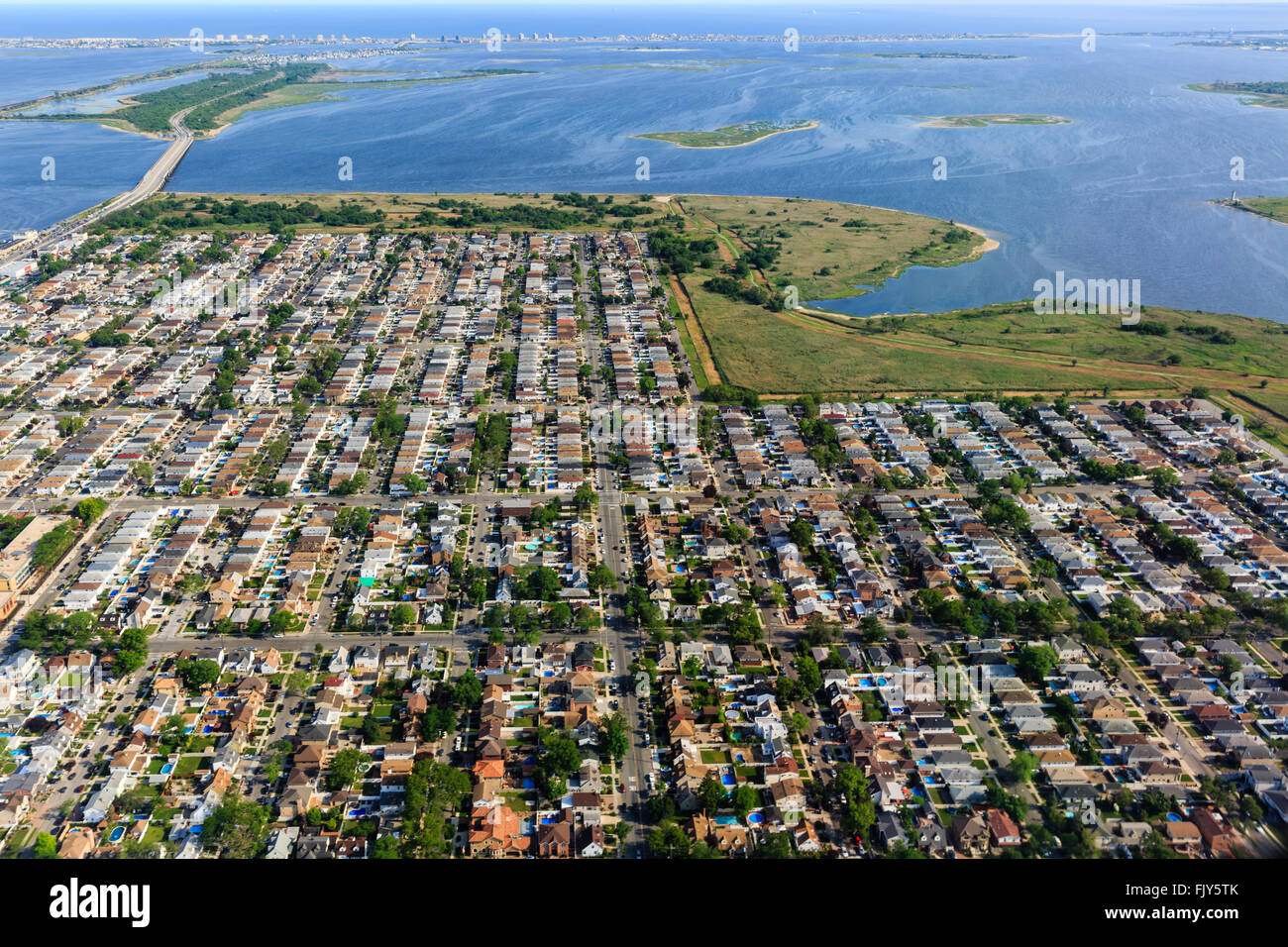 Aerial view at sunrise of housing in neighborhood on end of long island on approach to New York city airport Stock Photo