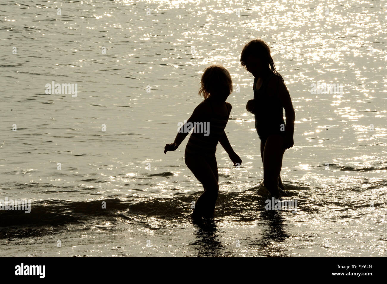 Child splashing in sparkling sea, Seaford, Easy Sussex, UK Stock Photo