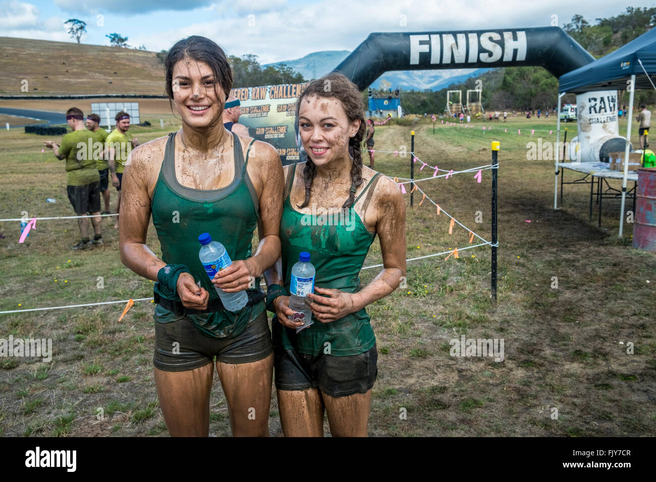 Two young women athletes at the finish line after competing in an 8km obstacle course Stock Photo