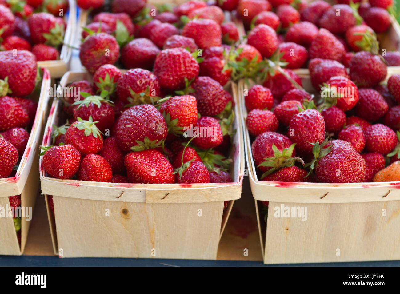 Freshly picked strawberries in baskets at the farmer's market Stock Photo