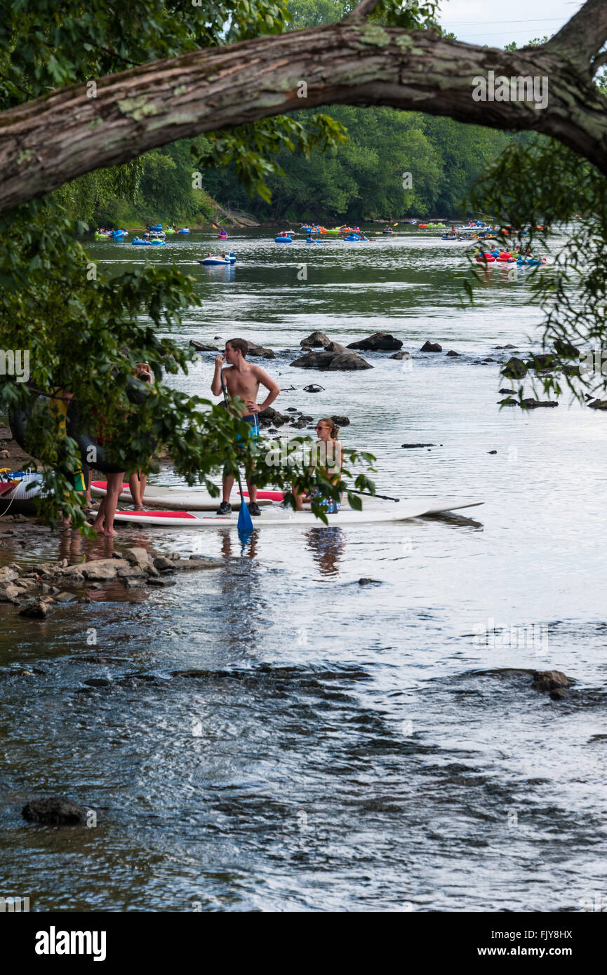 Poeple enjoying a weekend on the water with tubing and paddleboarding on the French Broad River in Asheviille, North Carolina. Stock Photo