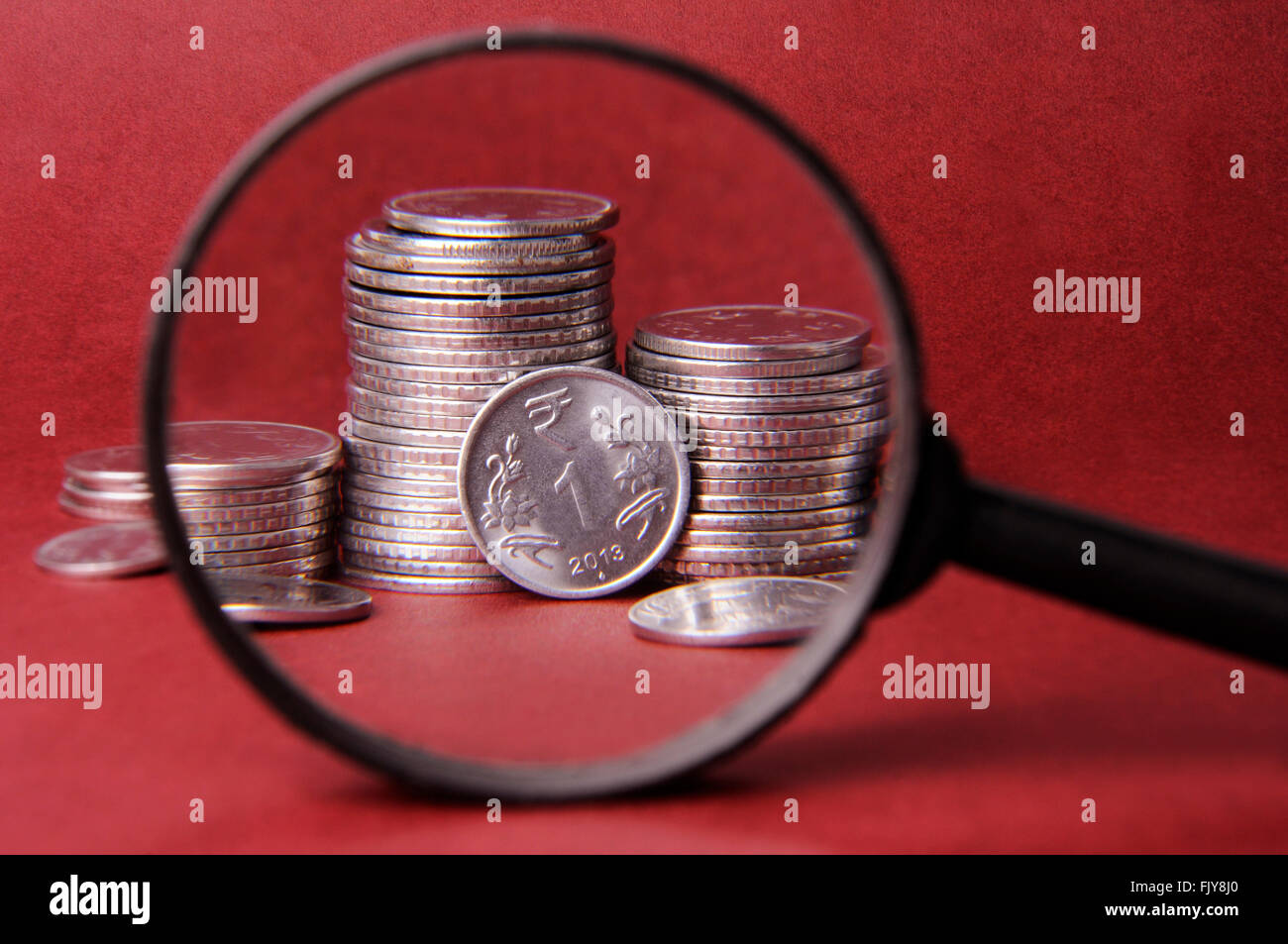 Magnifier and coins Stock Photo - Alamy