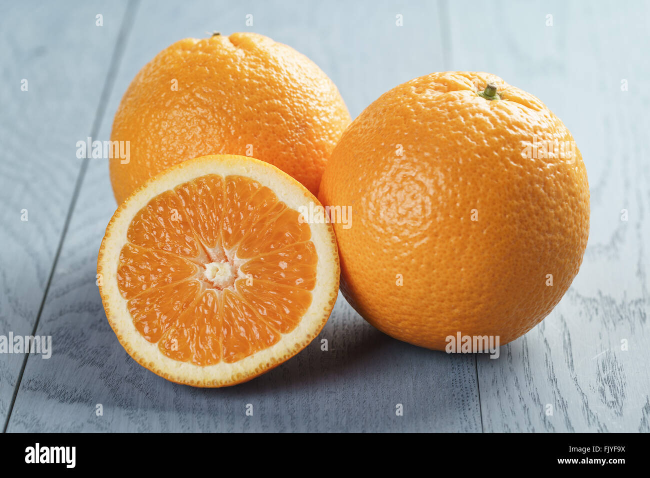 Orange With Ripe ripe oranges with half sliced on blue wood table Stock Photo - Alamy