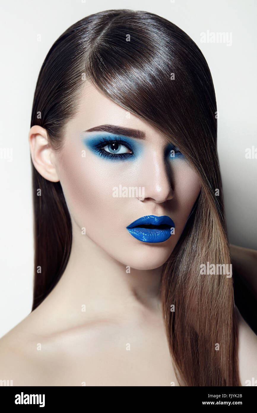 Girl with brown hair smooth silky straight hair and with blue ink and lipstick. Stock Photo