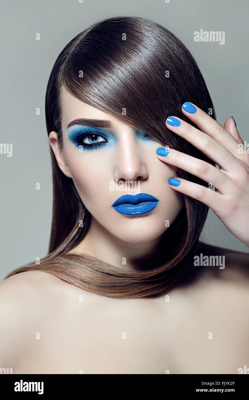 Girl with brown hair smooth silky straight hair and with blue ink and lipstick. Stock Photo