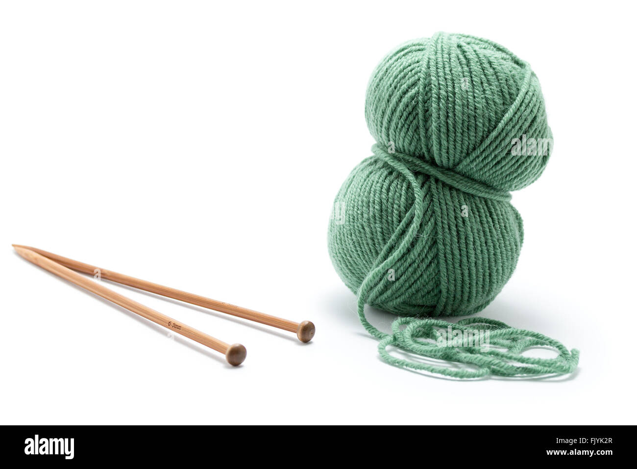Skein of green yarn with knitting needles Stock Photo