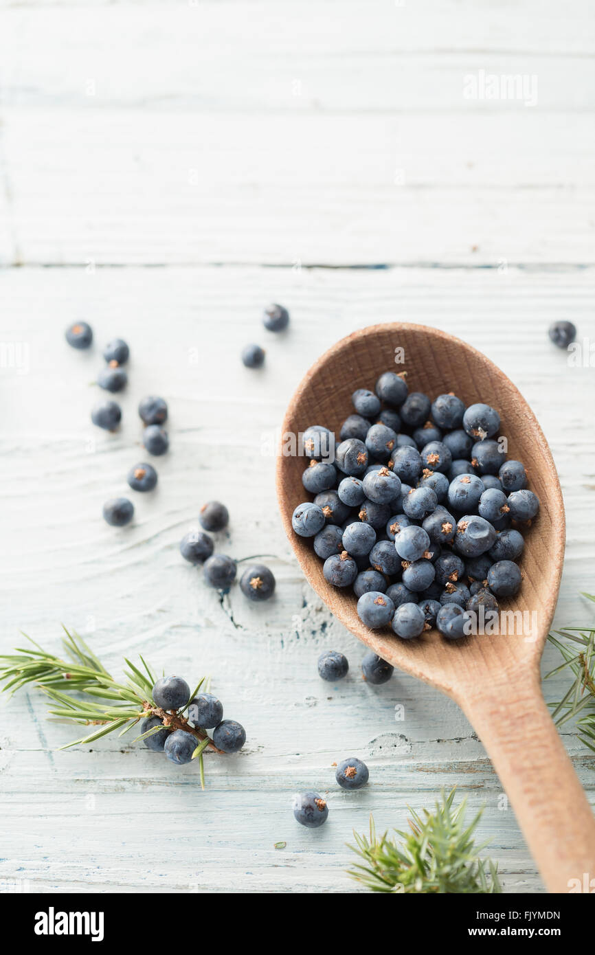 Wooden spoon with juniper berries Stock Photo