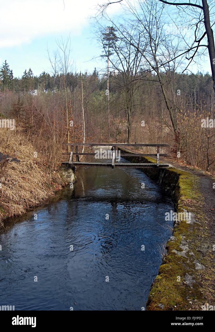 technical monument Weisshuhnuv kanal water channel with small wooden bridge near Hradec nad Moravici Stock Photo