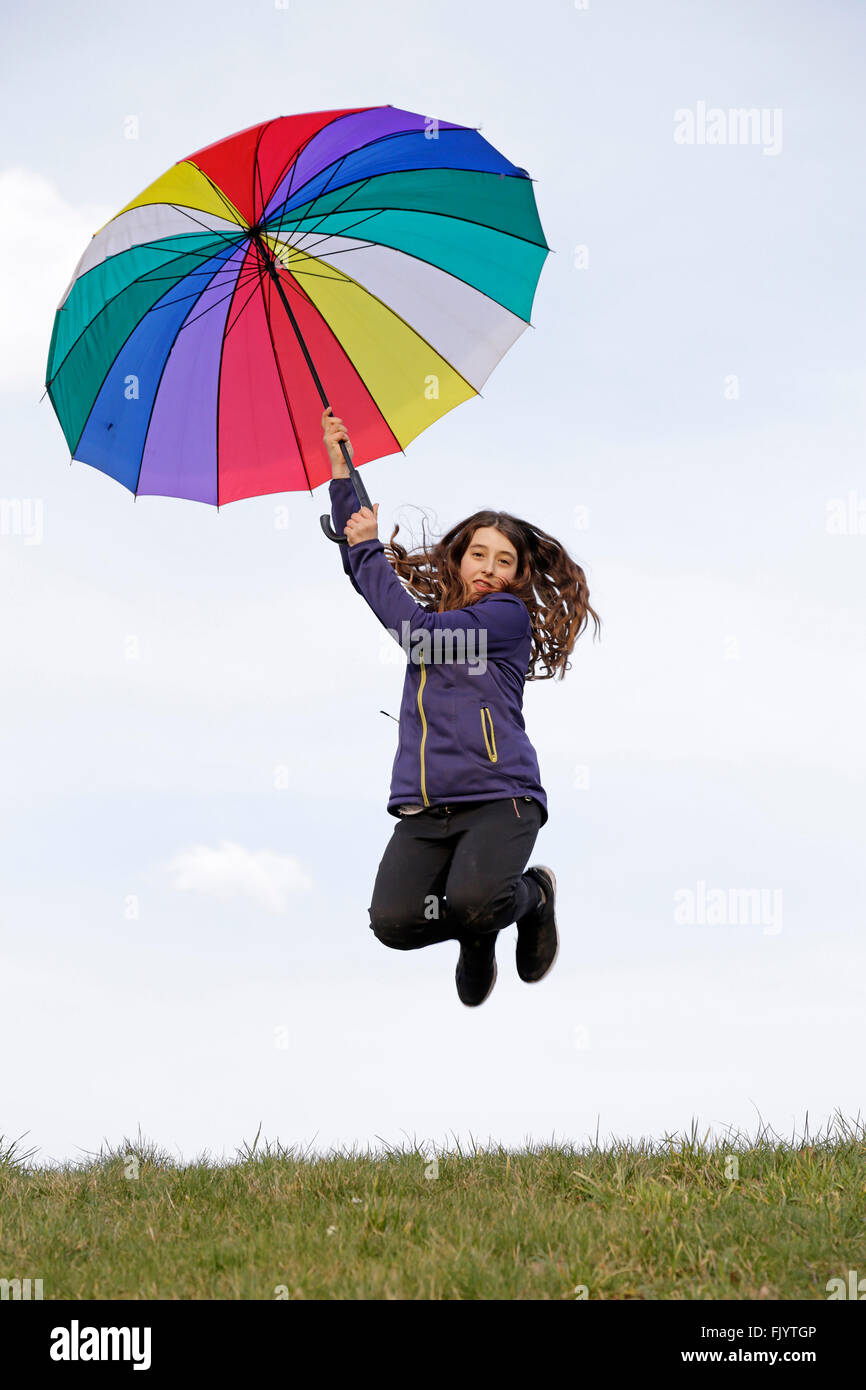 girl jumping with colourful umbrella Stock Photo - Alamy