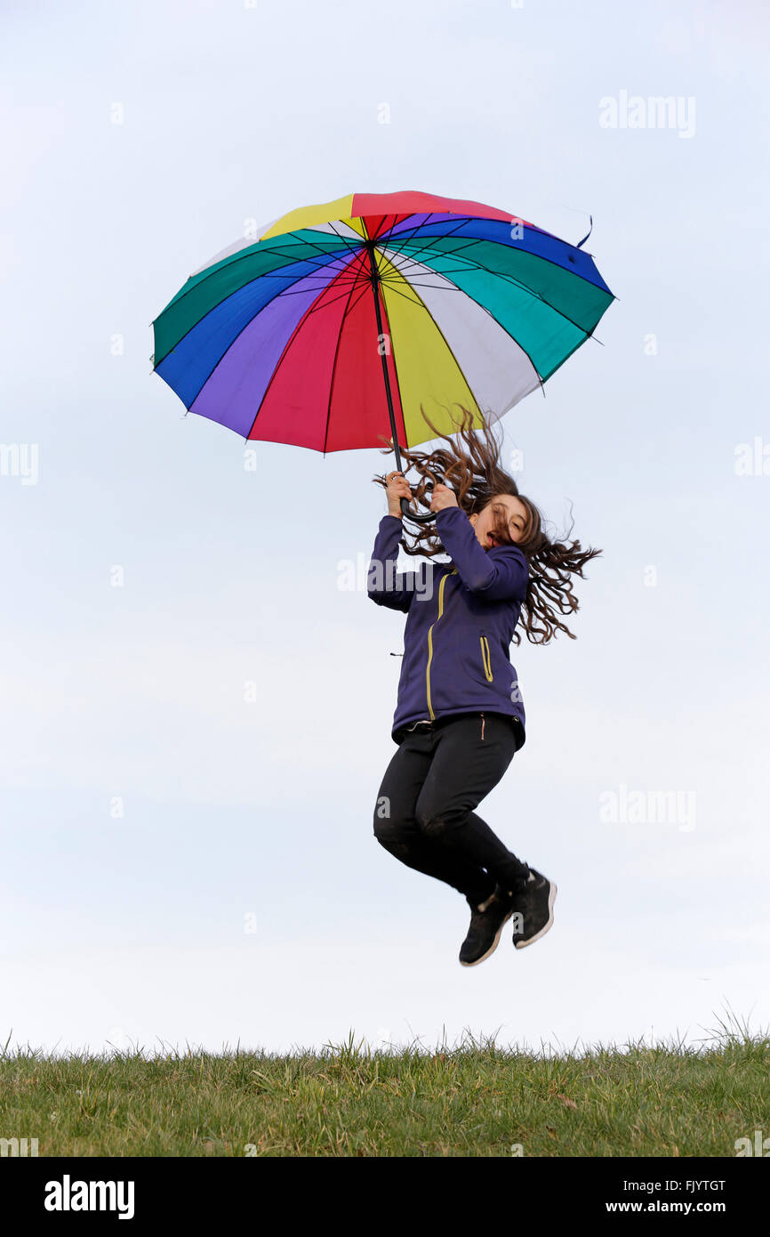 girl jumping with colourful umbrella Stock Photo - Alamy