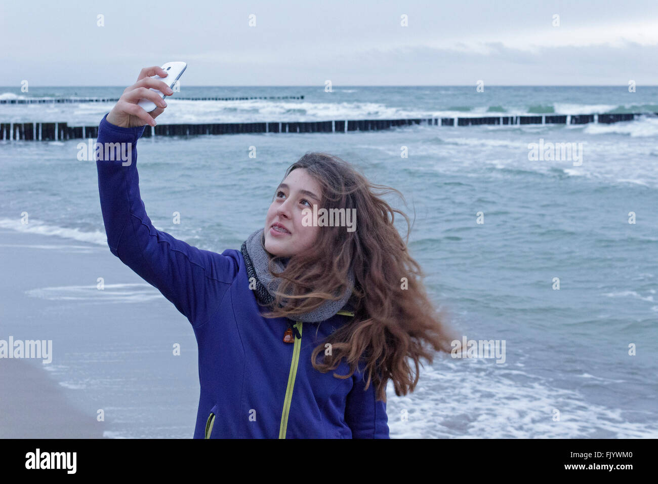 girl taking selfie at beach, Darss, Mecklenburg-West Pomerania, Germany Stock Photo