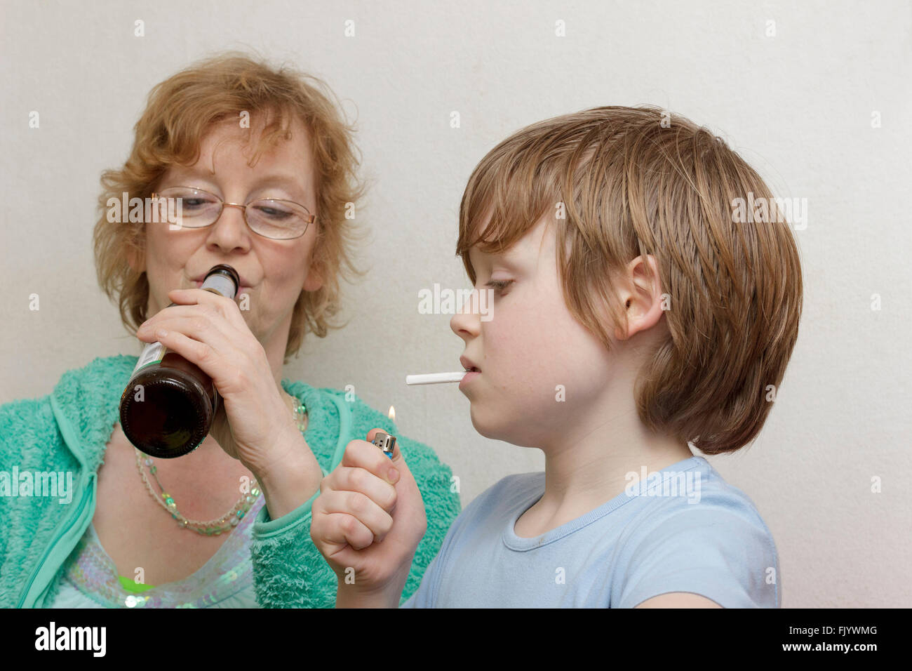 underage boy smoking, his mother drinking beer Stock Photo