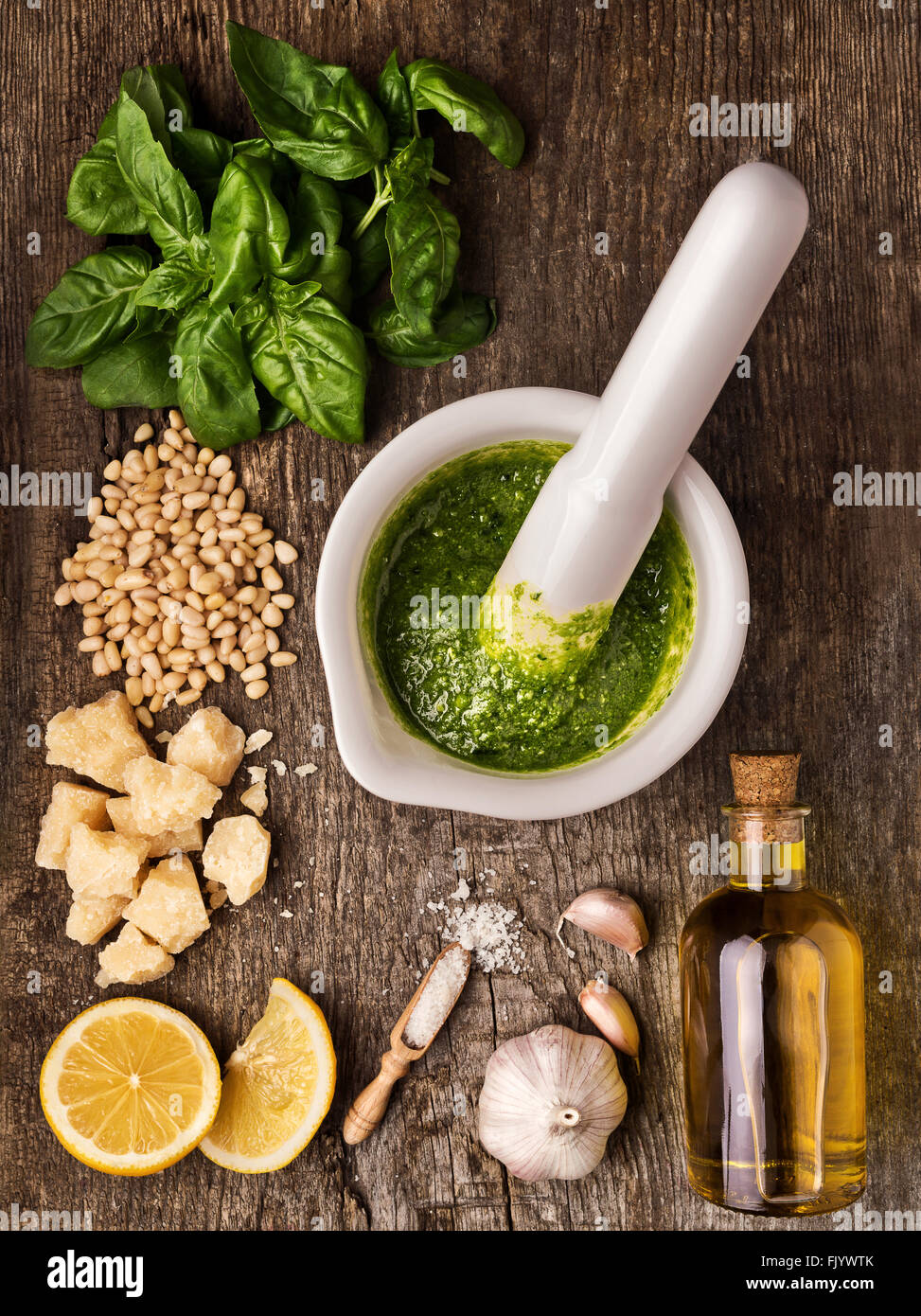 Sauce pesto and its ingredients on rough wood Stock Photo