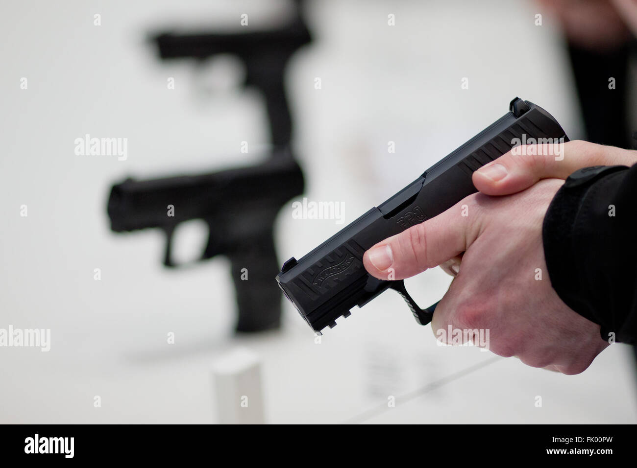 Nuremberg, Germany. 4th Mar, 2016. A visitor holding a gun of the