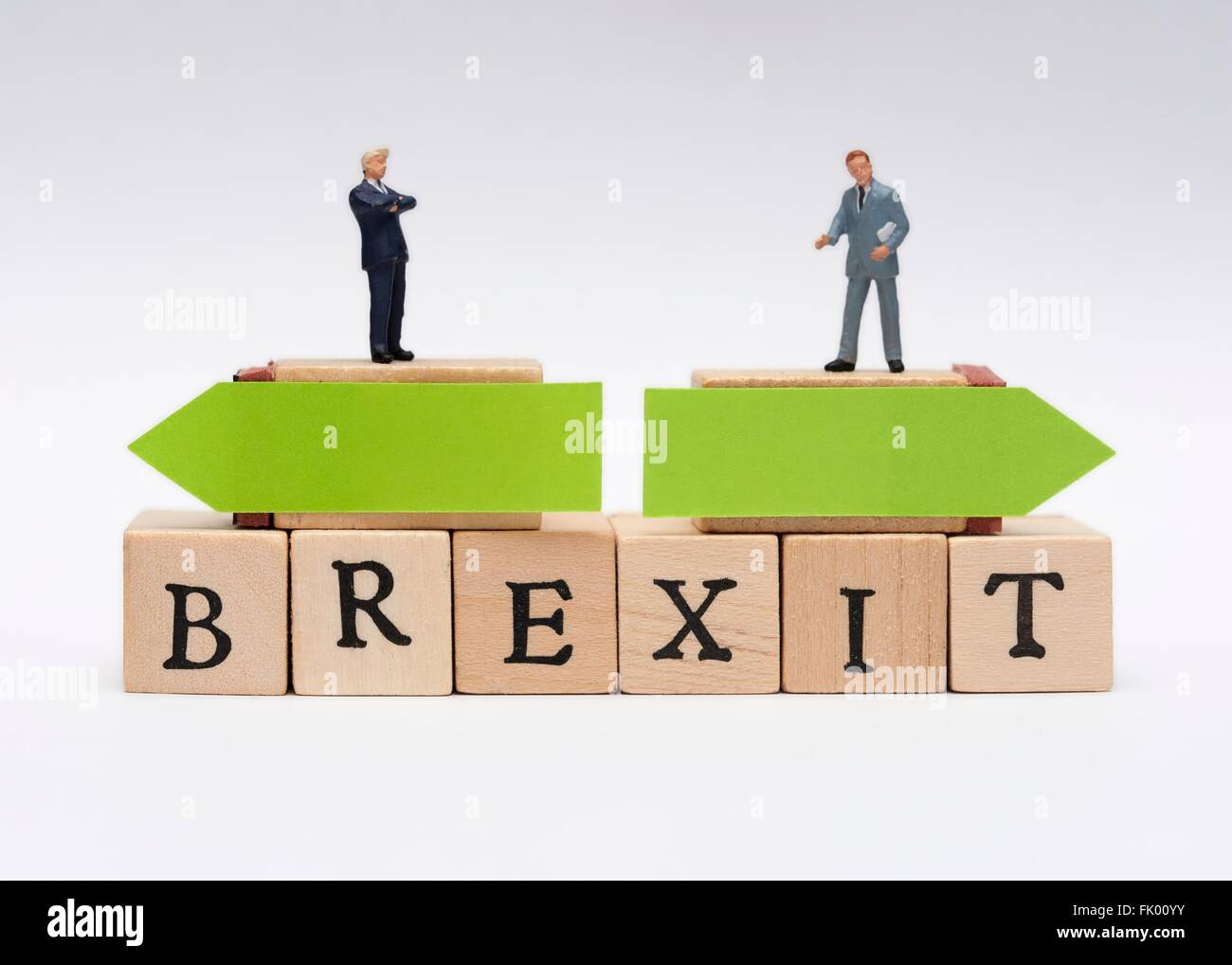 Miniature business men in suits standing on top of the word Brexit with opposing green arrows decision concept Stock Photo