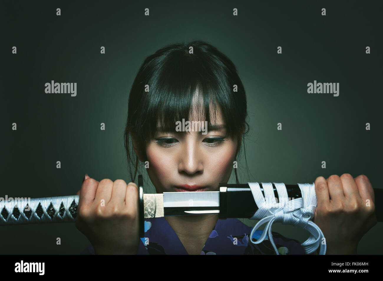 Beautiful japanese woman with katana . Studio dark shot Stock Photo