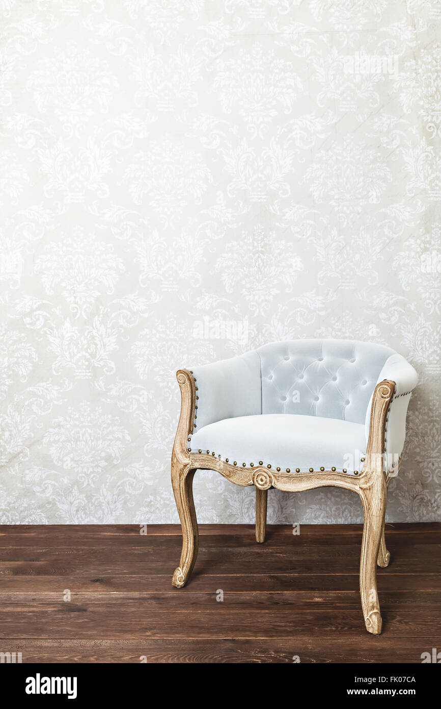 retro armchair on wallpaper background, wooden floor, copy space Stock