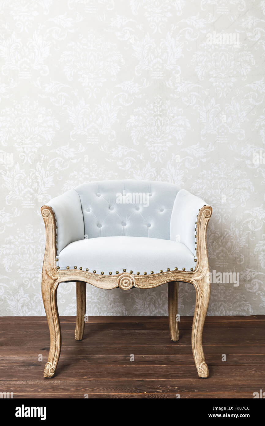 retro armchair on wallpaper background, wooden floor, copy space Stock