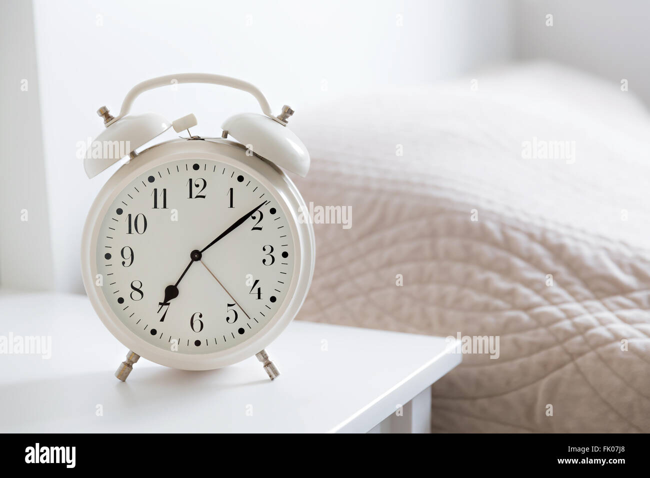 retro white alarm clock on white table in the bedroom Stock Photo Alamy