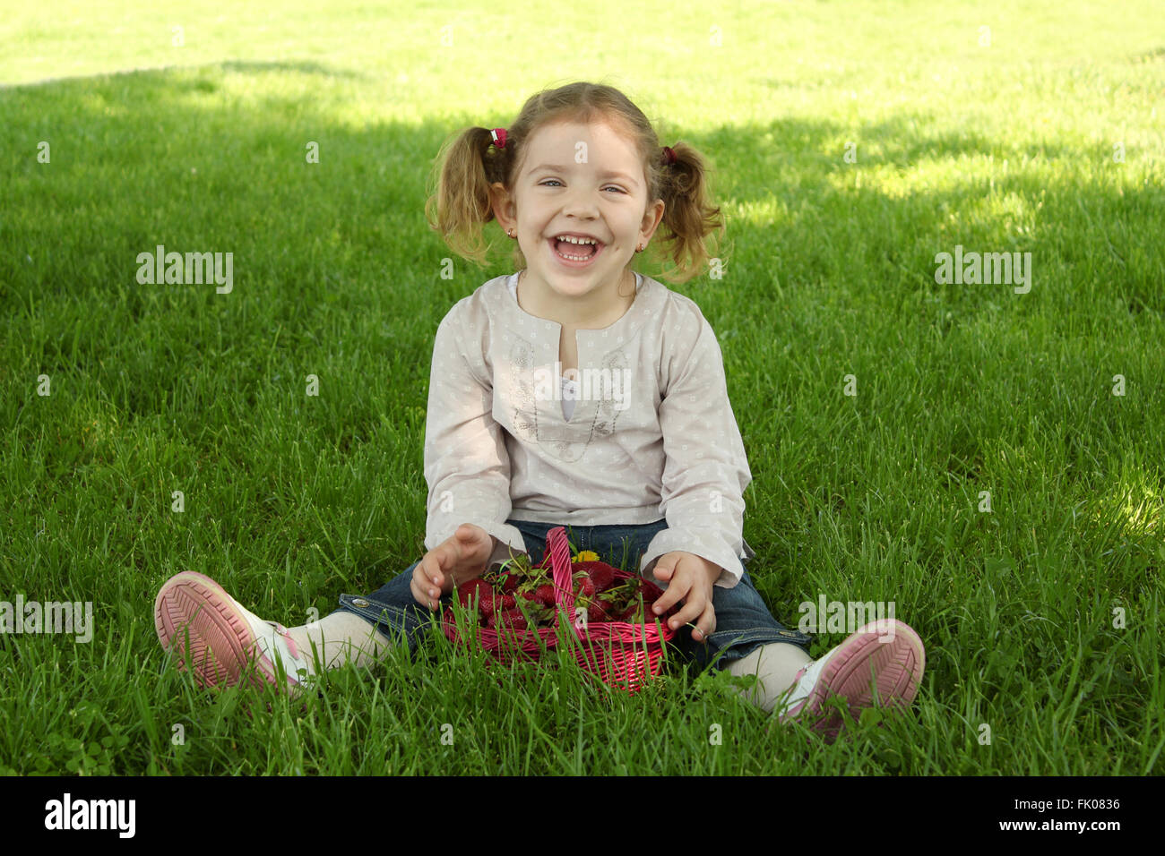 happy young girl sitting on grass in park Stock Photo - Alamy