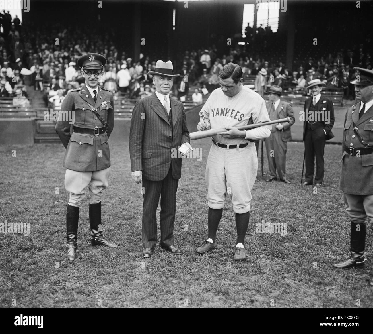 Secretary of War James W. Good Watching Babe Ruth of New York Yankees Signing First of Many Bats to be Awarded as Prizes at Stock Photo