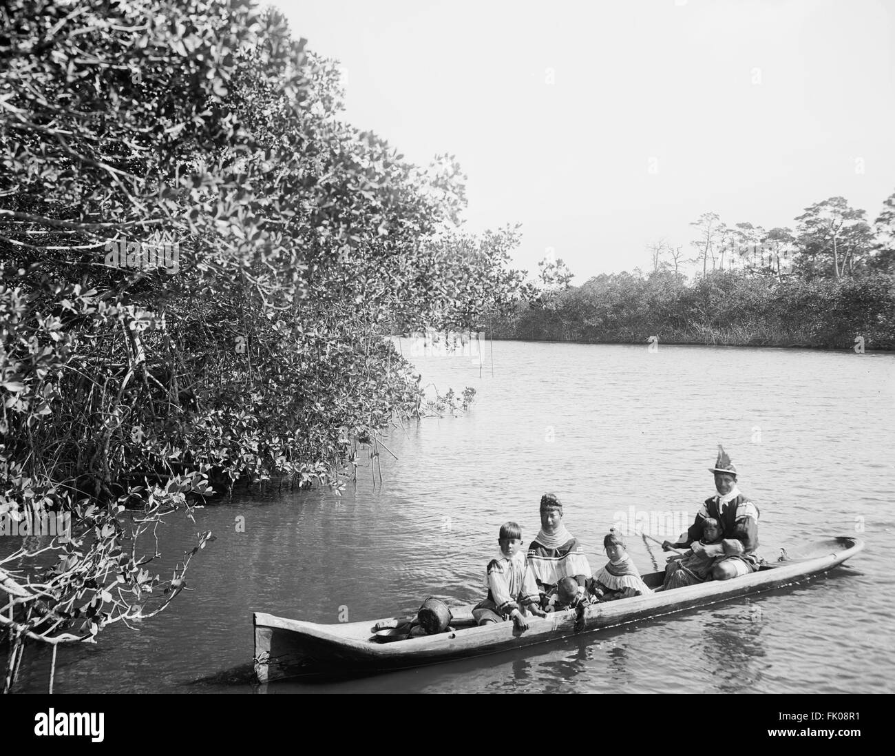 Seminole Native American Family in Dugout Canoe, Miami, Florida, USA, circa 1915 Stock Photo