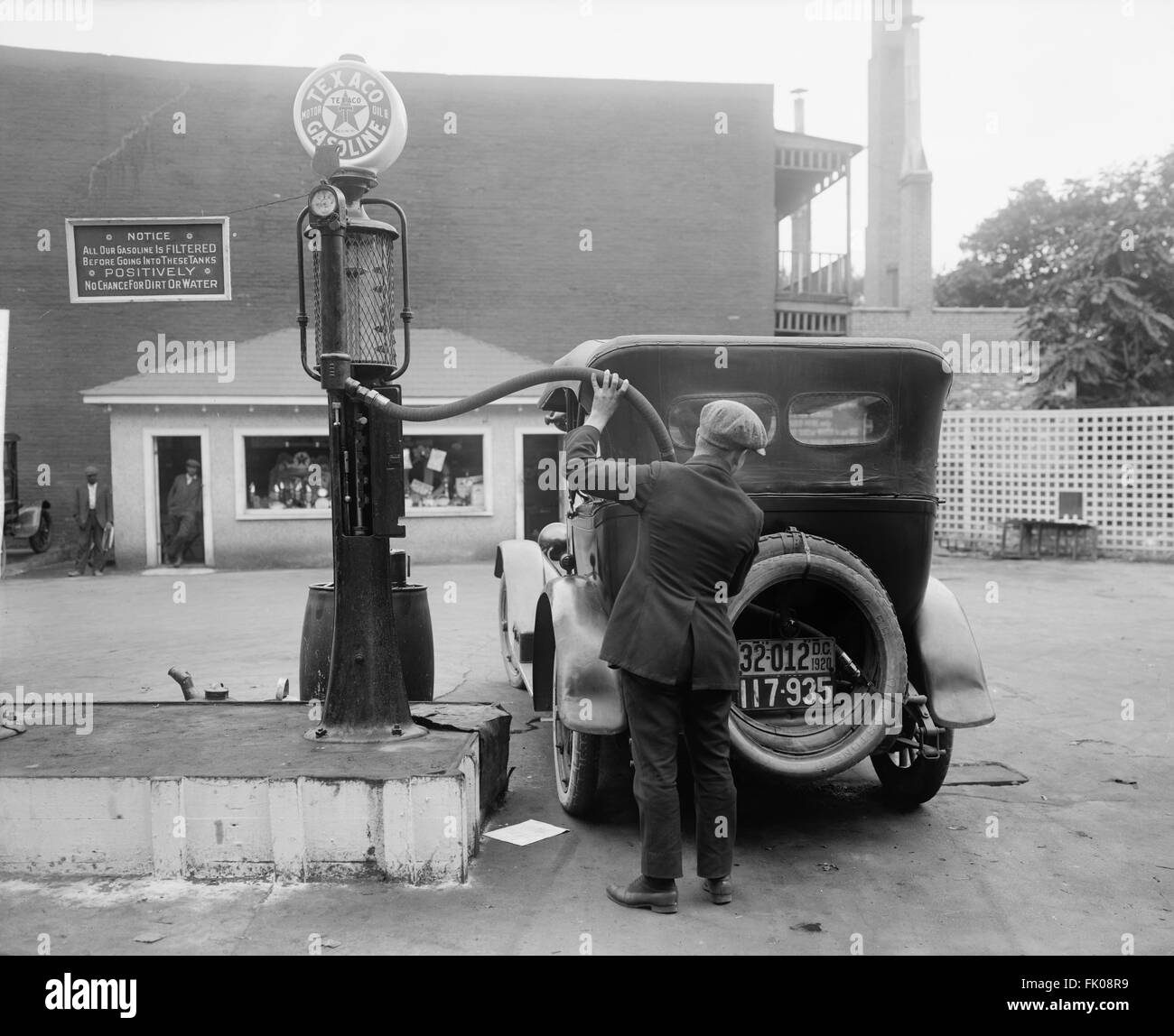 Man Putting Gas in Car at Gas Station, Washington DC, USA, circa 1920 Stock Photo
