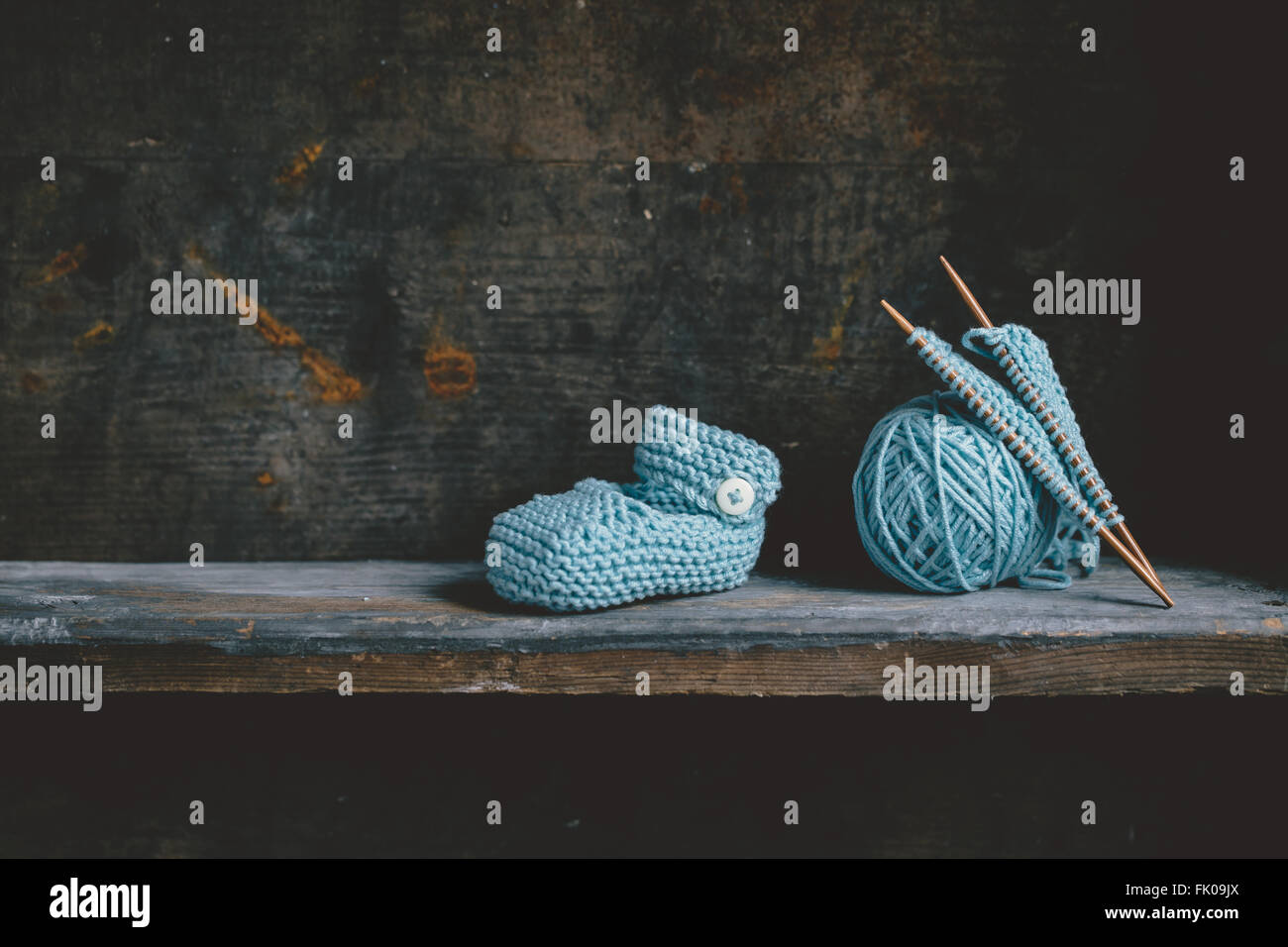 Knitting baby shoes with blue yarn Stock Photo - Alamy