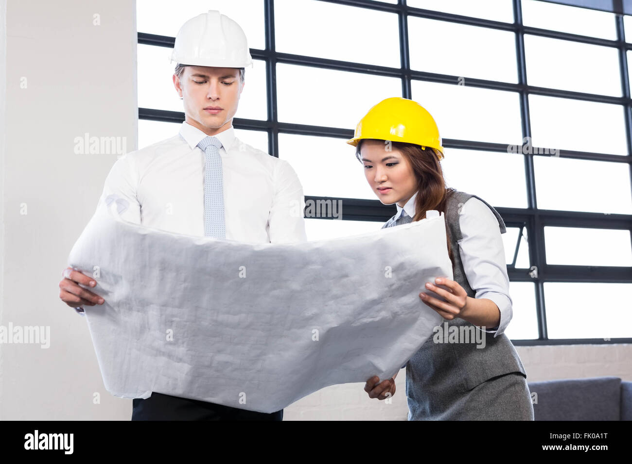 Architects looking at blueprint Stock Photo
