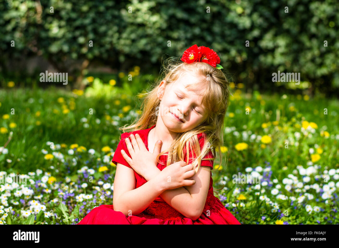 beautiful blond girl sitting with closed eyes in flower meadow Stock ...